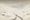 Vintage gouache painting of a cyclist riding up a snowy mountain dirt road during a severe Gavia Pass cycling ascent.