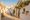 Narrow whitewashed alley between traditional trulli with conical limestone roofs in warm morning light, Alberobello, Puglia, southern Italy