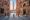 Empty Piazza del Campo and Torre del Mangia at dawn, seen down a Siena lane, where the Palio di Siena runs