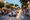 A 1930s roadster with lit headlights passes applauding crowds at dusk during the Mille Miglia 2026