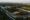 Aerial view of a curve at the Autodromo Nazionale Monza at dusk, grandstands lining the track