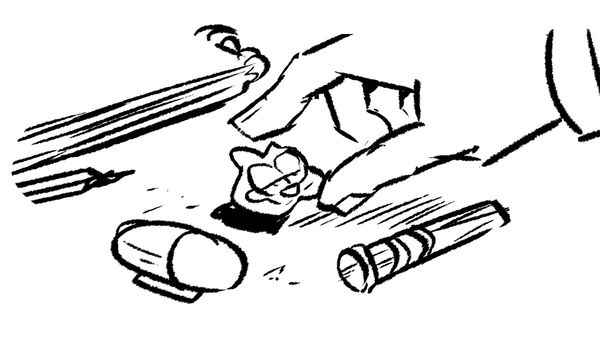 a hand picks up a garfield eraser and places it between a small pill-shaped highlighter and an empty pencil extender