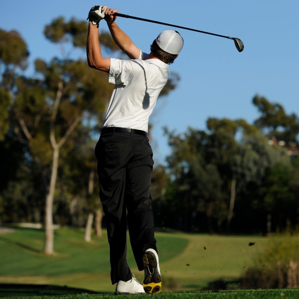 A golfer comparing different golf clubs