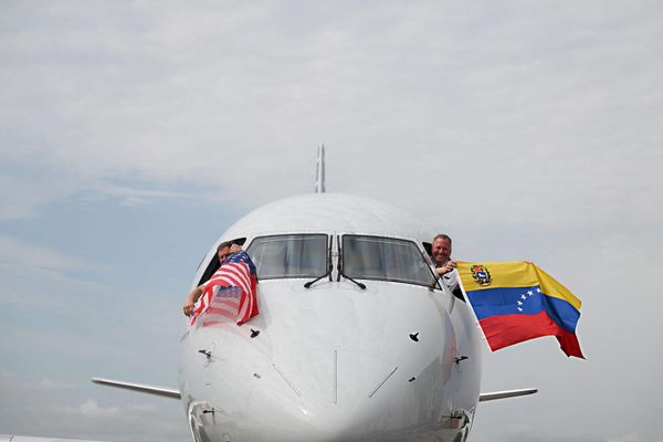  Pilots of American Airlines Flight 3599, operating from Miami International Airport to Caracas, Venezuela, wave Venezuelan and US flags before departing on a nonstop flight to Venezuela