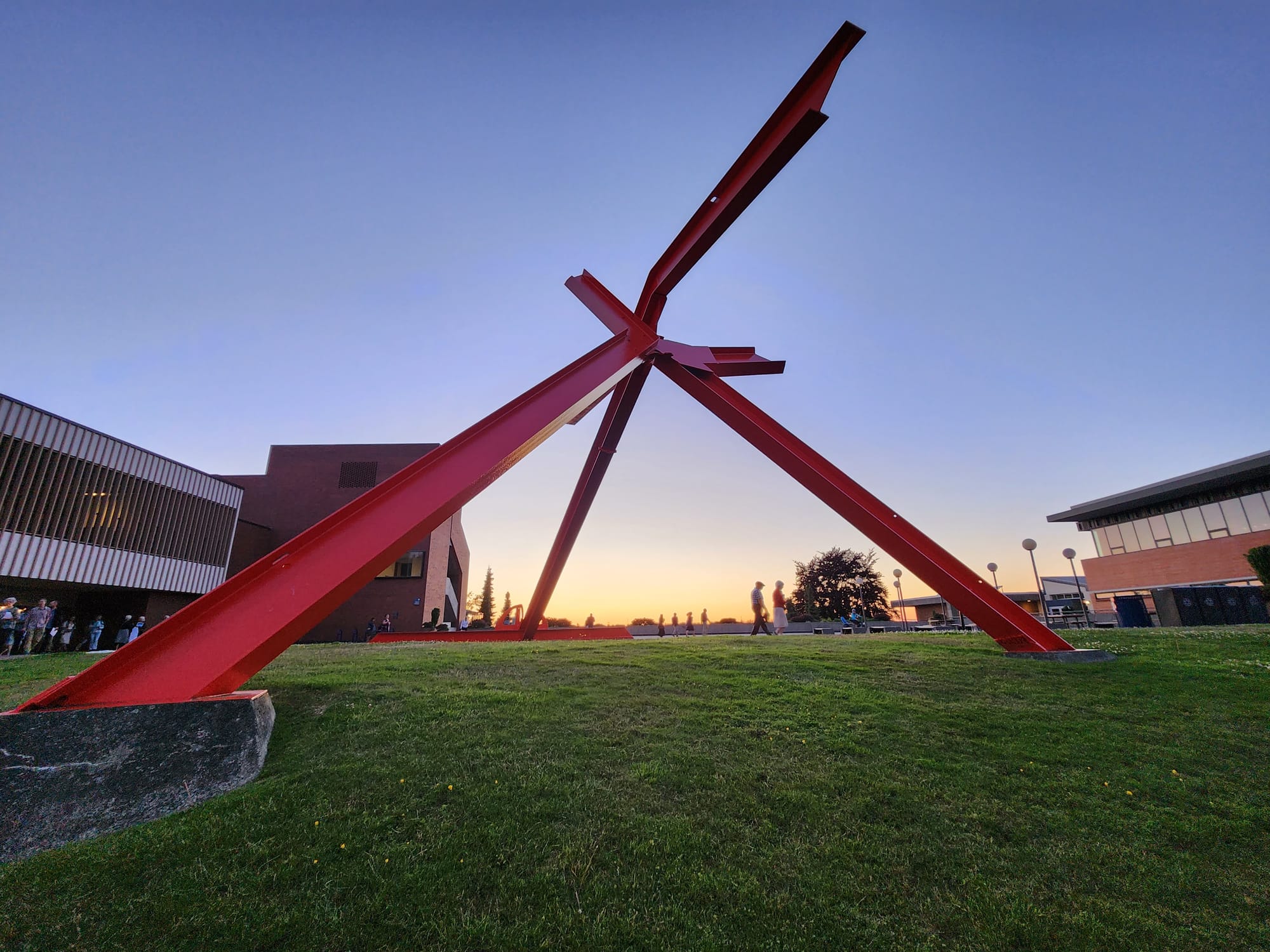A sunset shot of a red abstract sculpture.