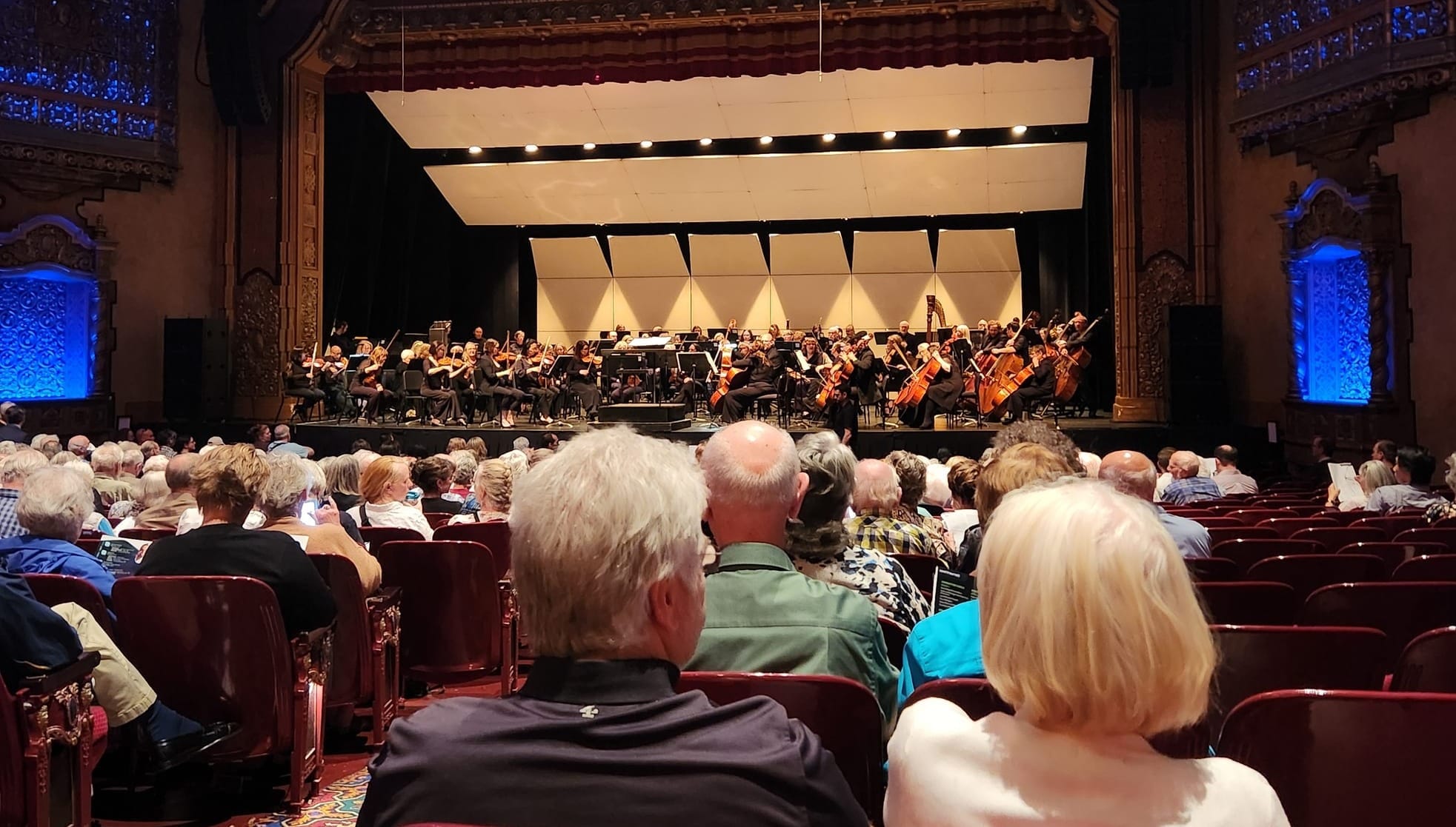 A symphony orchestra on stage in front of a full audience.