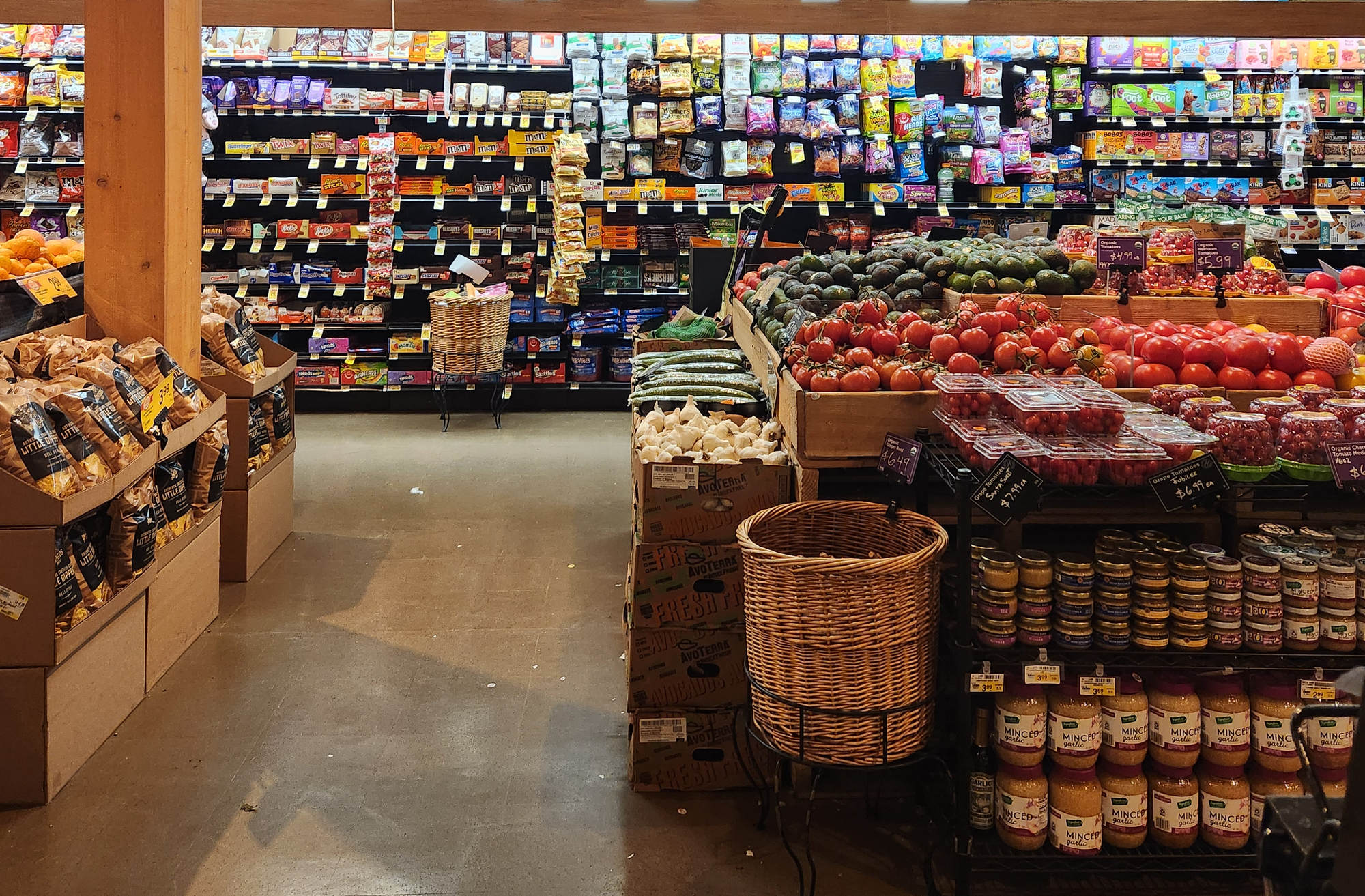 A grocery store interior with some fresh produce in the foreground.