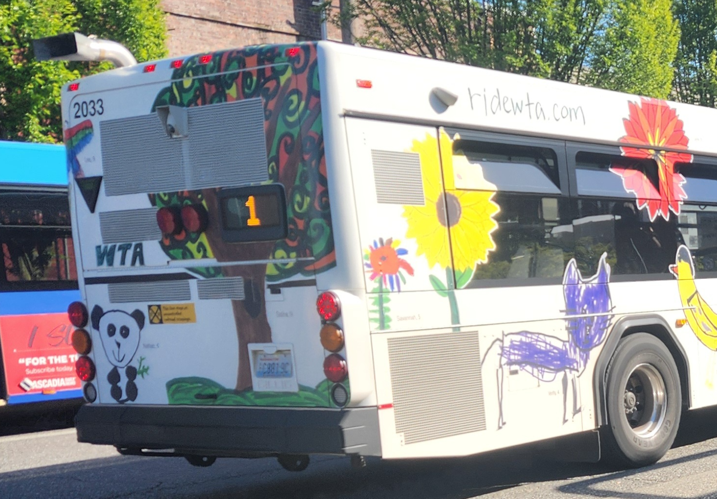 A WTA bus with a wrapping that includes children's art.