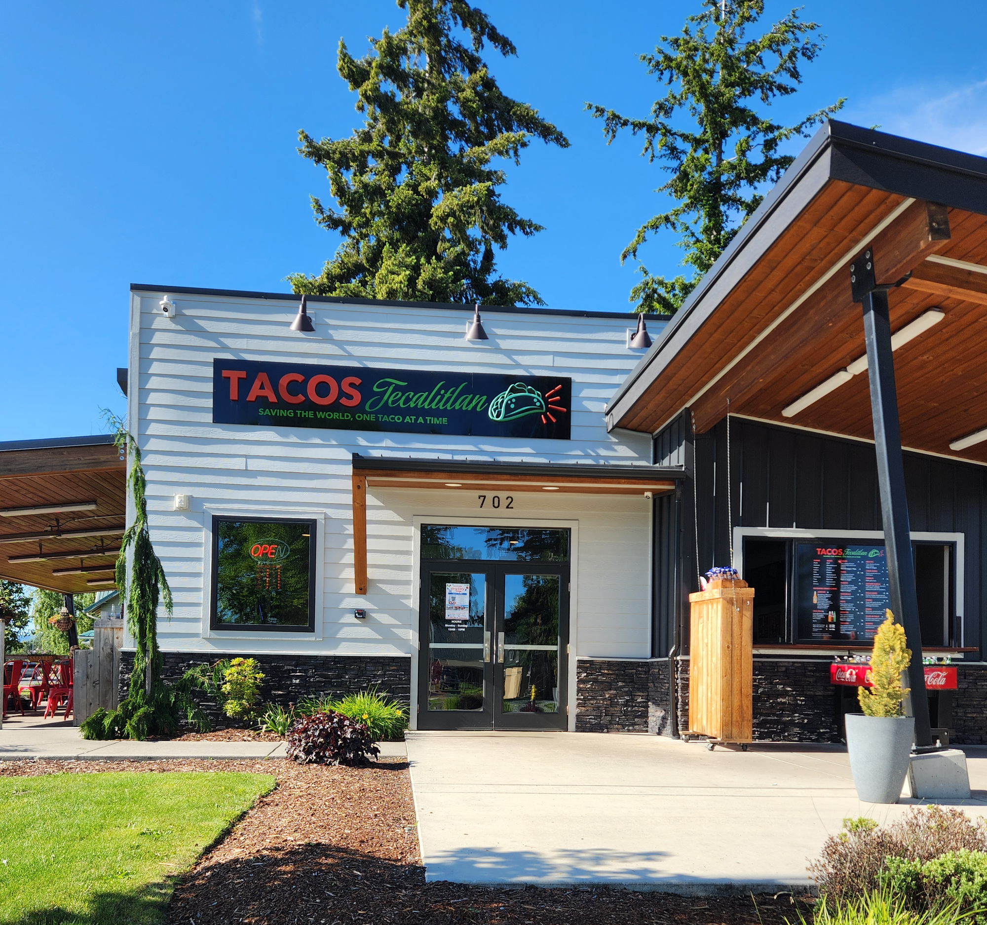 The exterior of a taqueria with a walk-up ordering window.