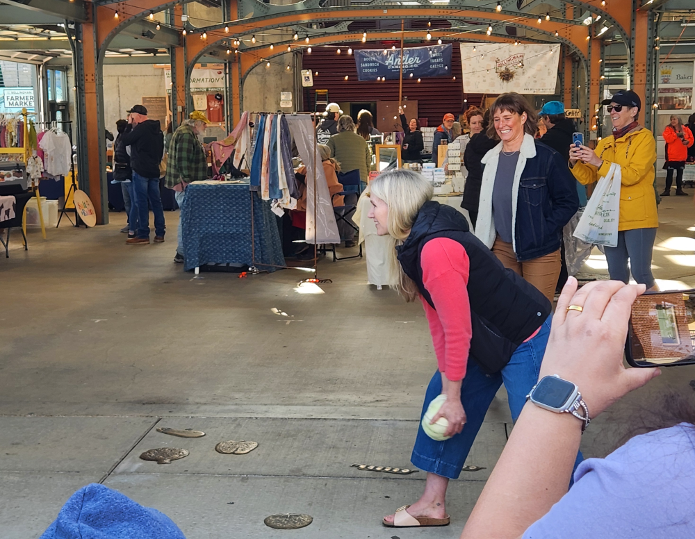 Bellingham Mayor Kim Lund tossing the ceremonial cabbage on Saturday at the Bellingham Farmers Market. 