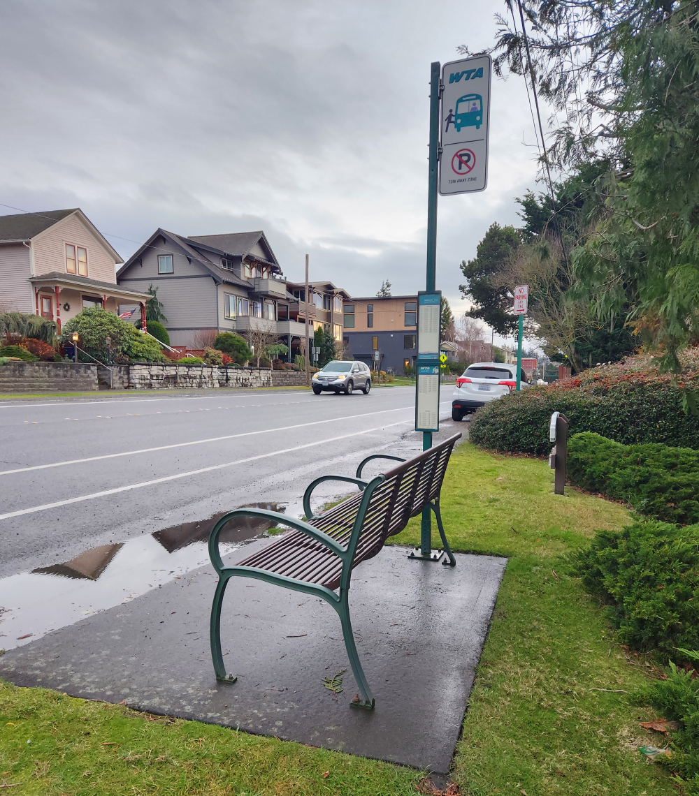 A bus stop with a bench but no adjacent sidewalks.