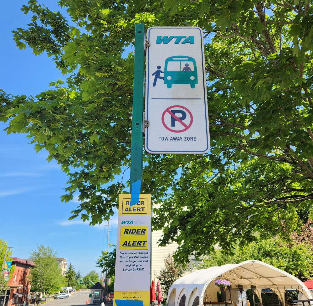 A bus stop with a yellow "Rider Alert" sign noting that the stop would be no longer in service starting Sunday.