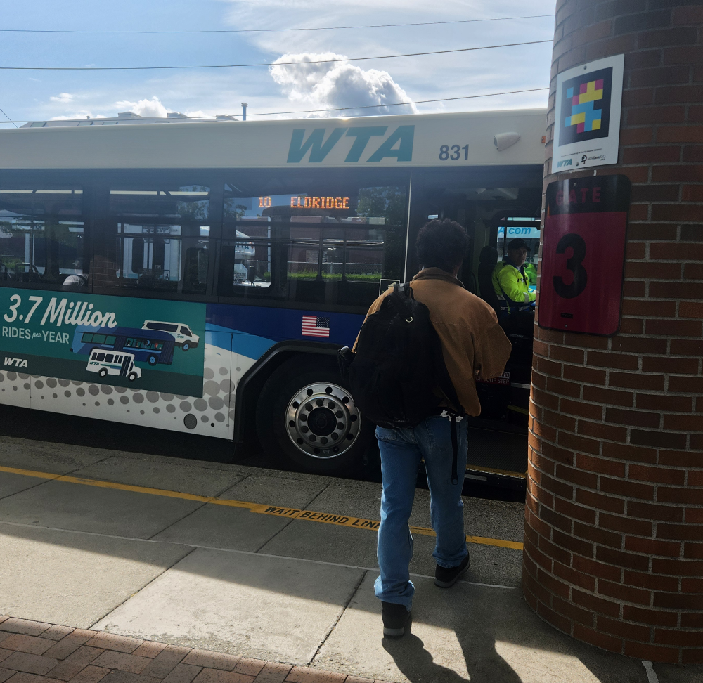 A person with a backpack stands in front of the open door of a Route 10 (Eldridge) bus.