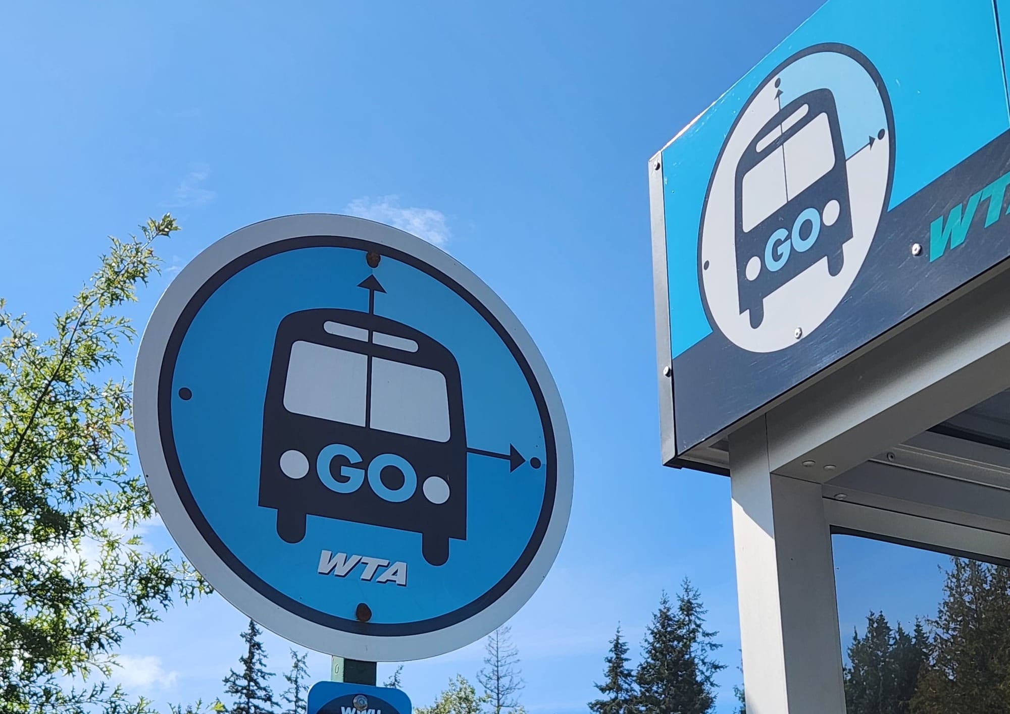 Blue colored signs for the Blue GO Line at a bus stop. 