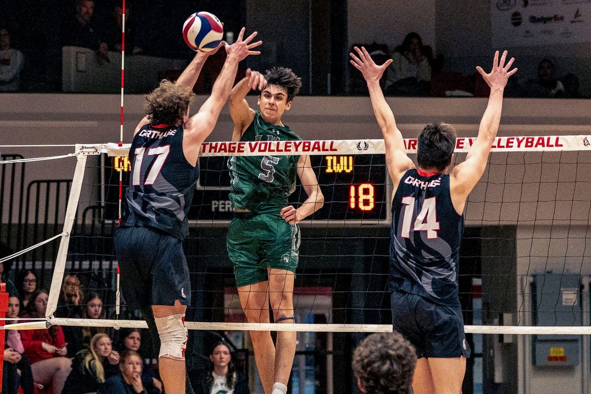 Carthage and Illinois Wesleyan men's volleyball players blocking at the net