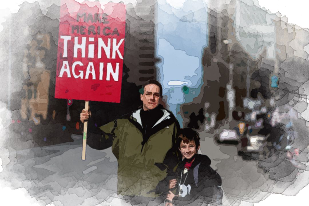 man beside boy holding red and white rally signage