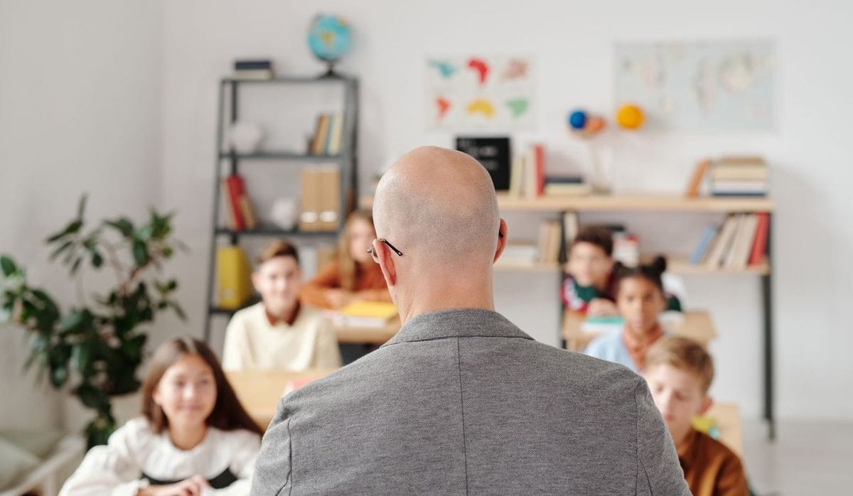 Teacher facing his students 