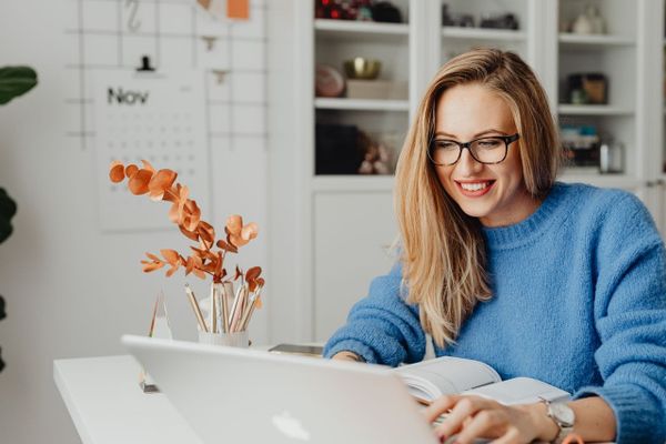 Lady in blue jumper working on an Apple computer