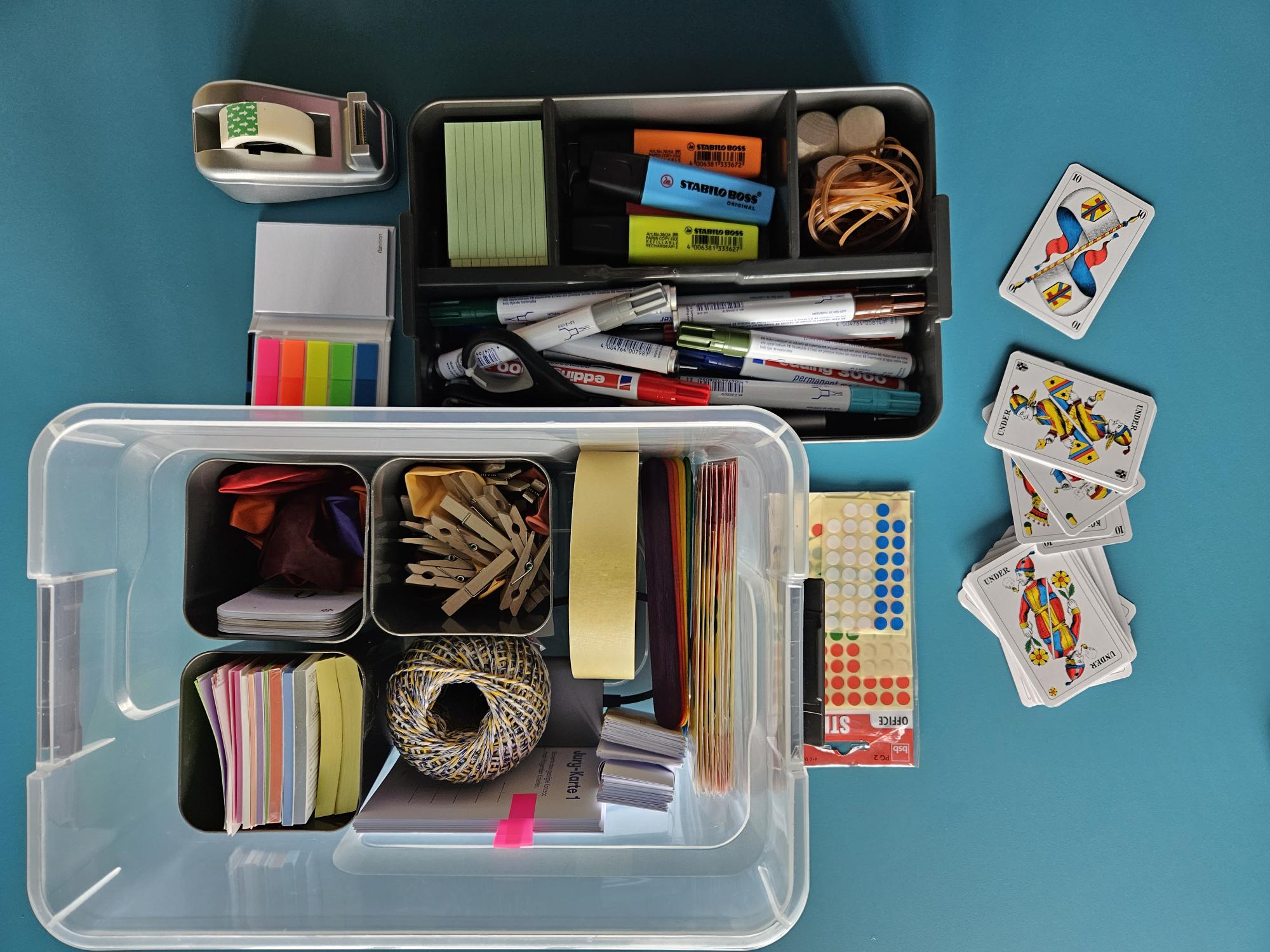 Workshop-Box mit diversen Inhalten: Schreibmaterial, Sticker, Karten, Klebeband etc.