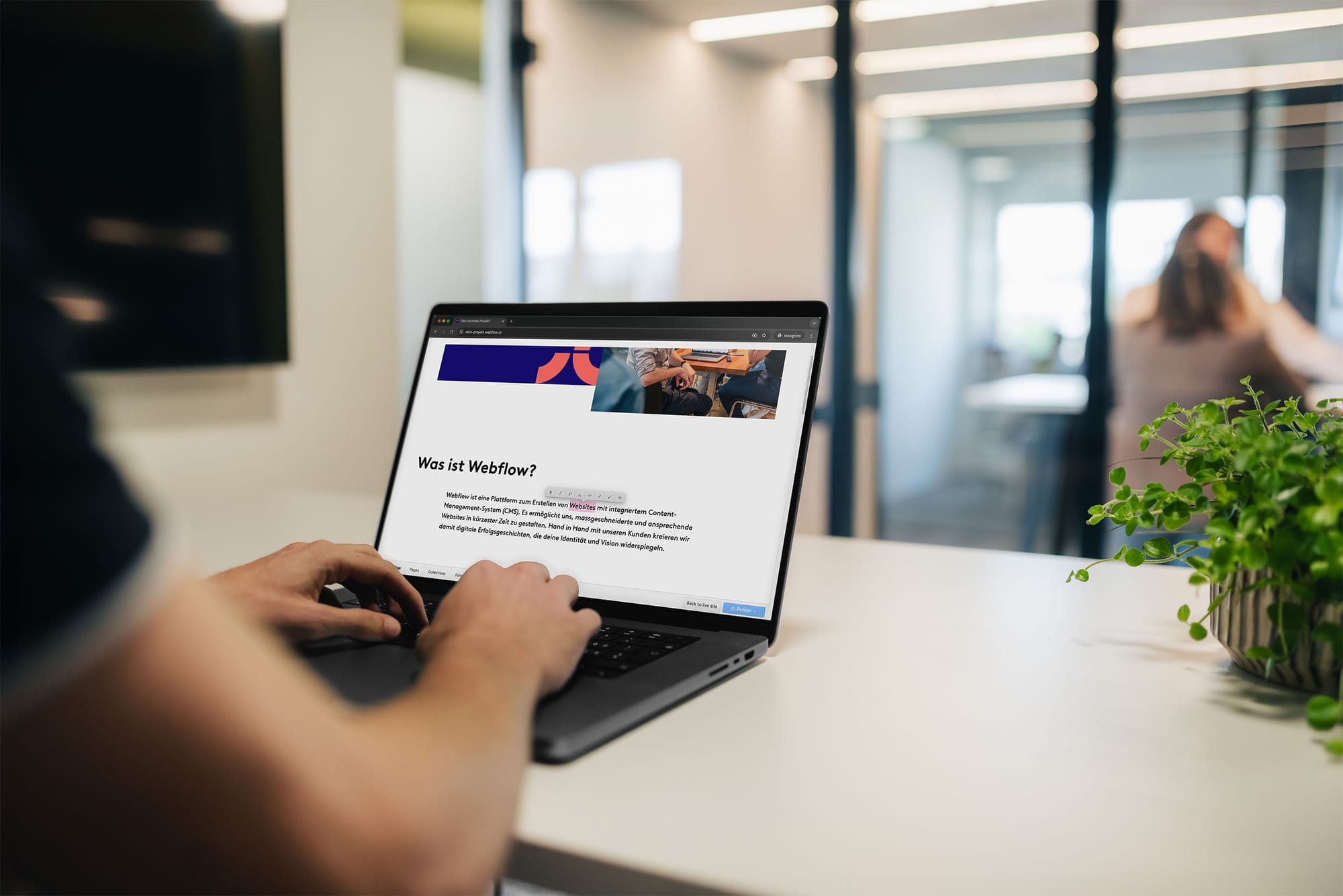 Eine Person arbeitet in einer modernen Büroumgebung an einem Laptop und bearbeitet den Website-Inhalt im Webflow-Editor.
