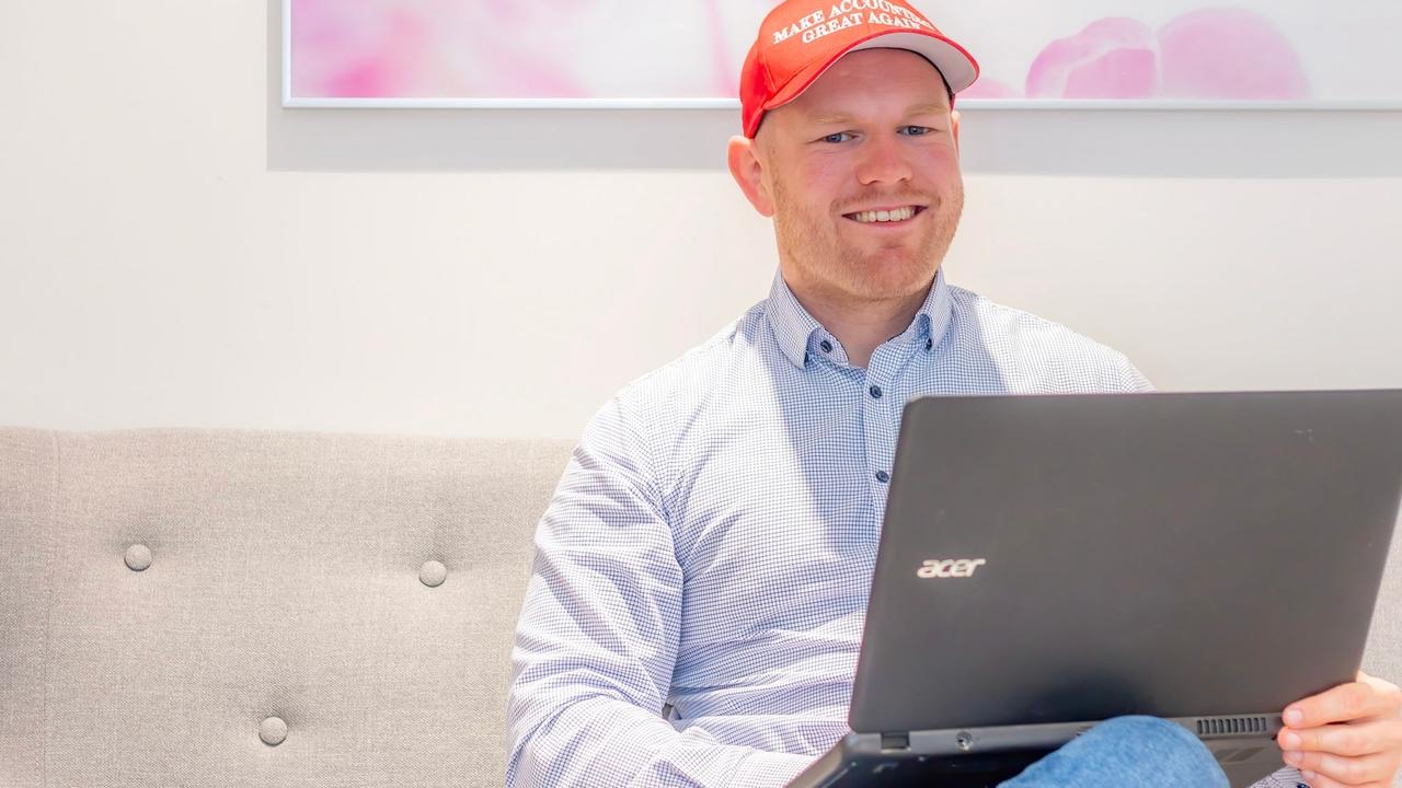 Fotografi av person som sitter i sofa med datamaskin i fanget