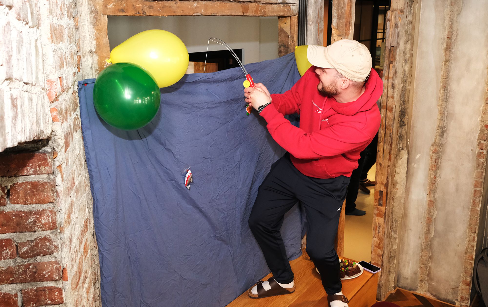 Fotografi av en Fiken-ansatt som fisker premier over et forheng