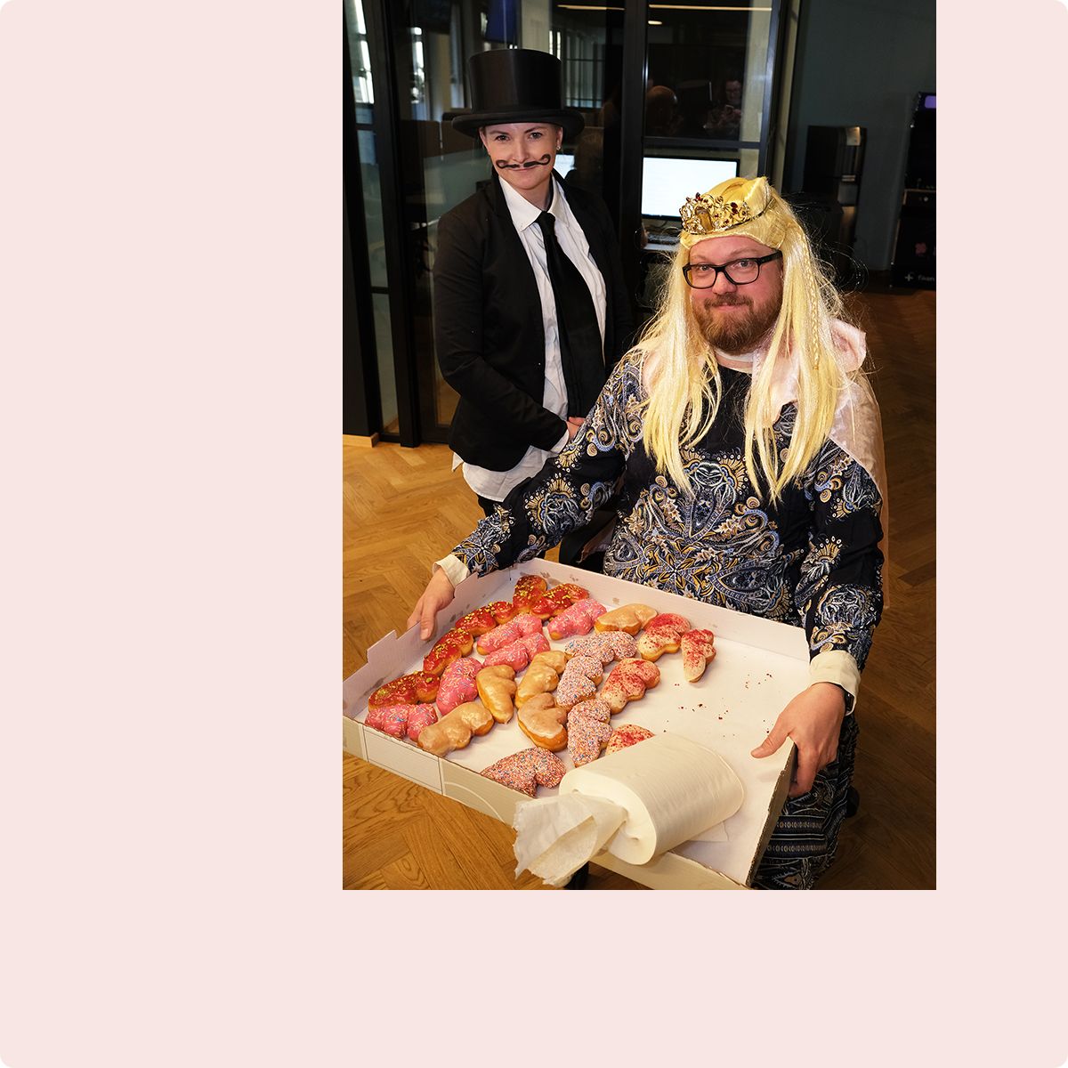 Fotografi av to Fiken-ansatte som serverer smultringer