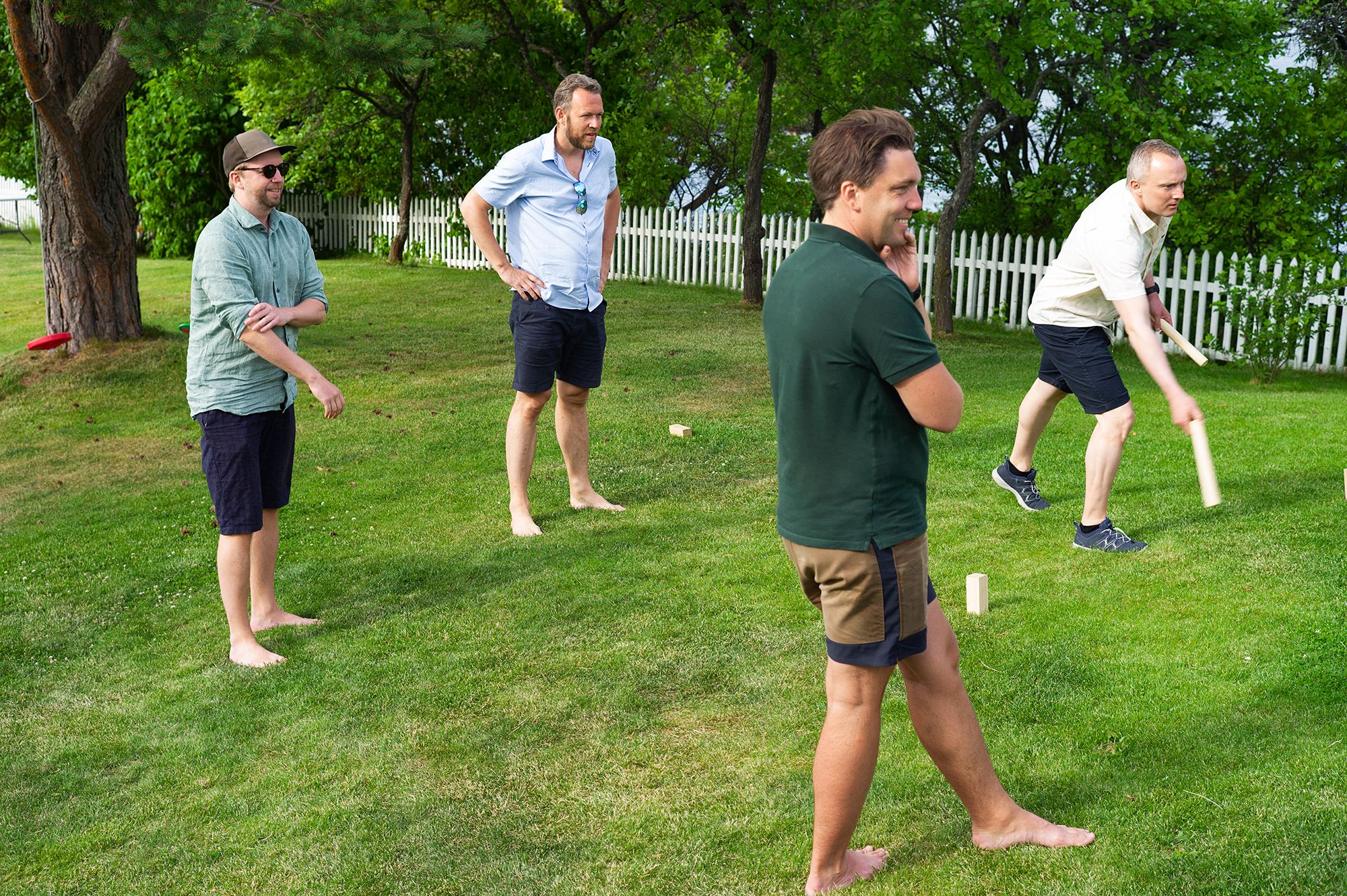 Fotografi av fire Fiken-ansatte som spiller kubb