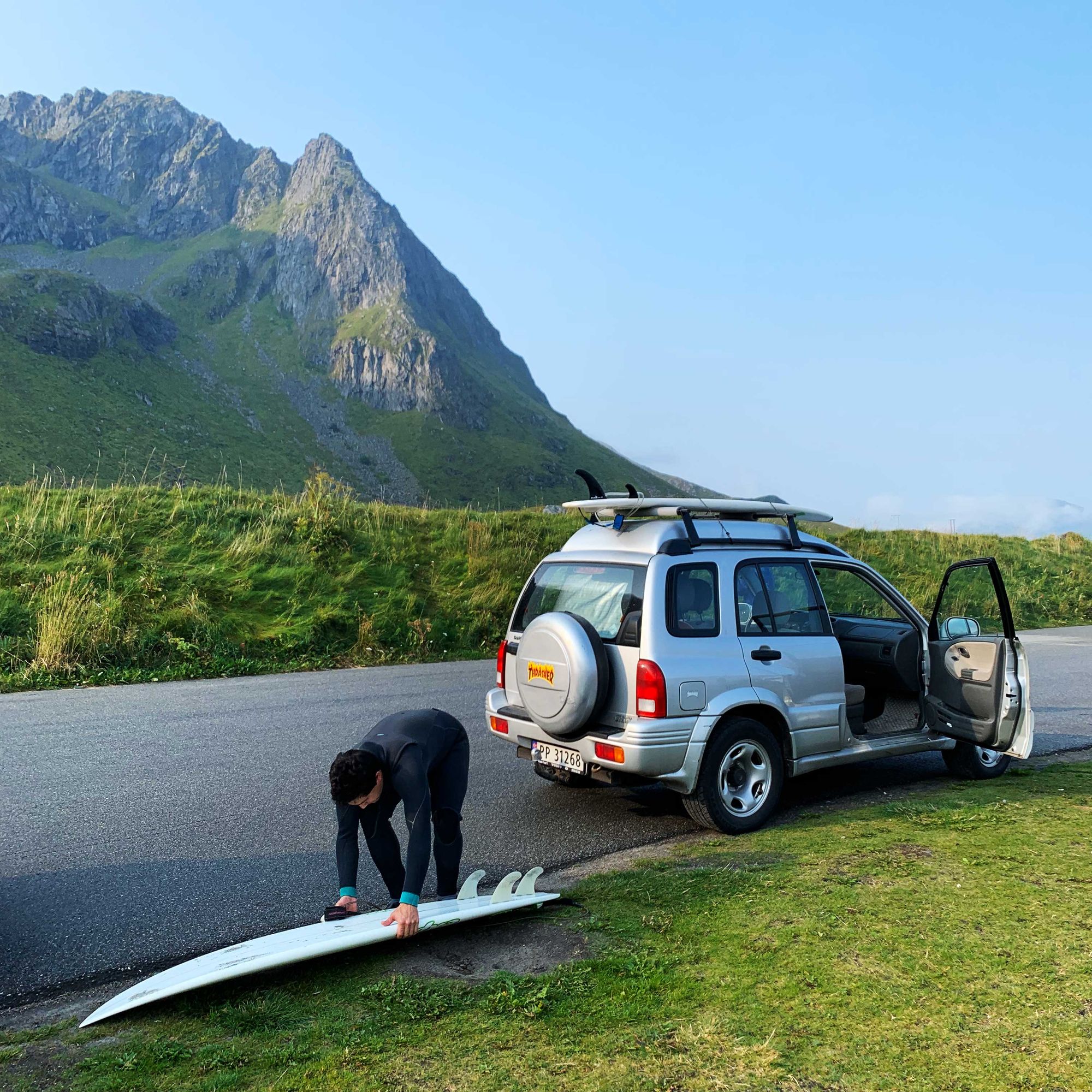 Fotografi av person som gjør seg klar til å surfe.