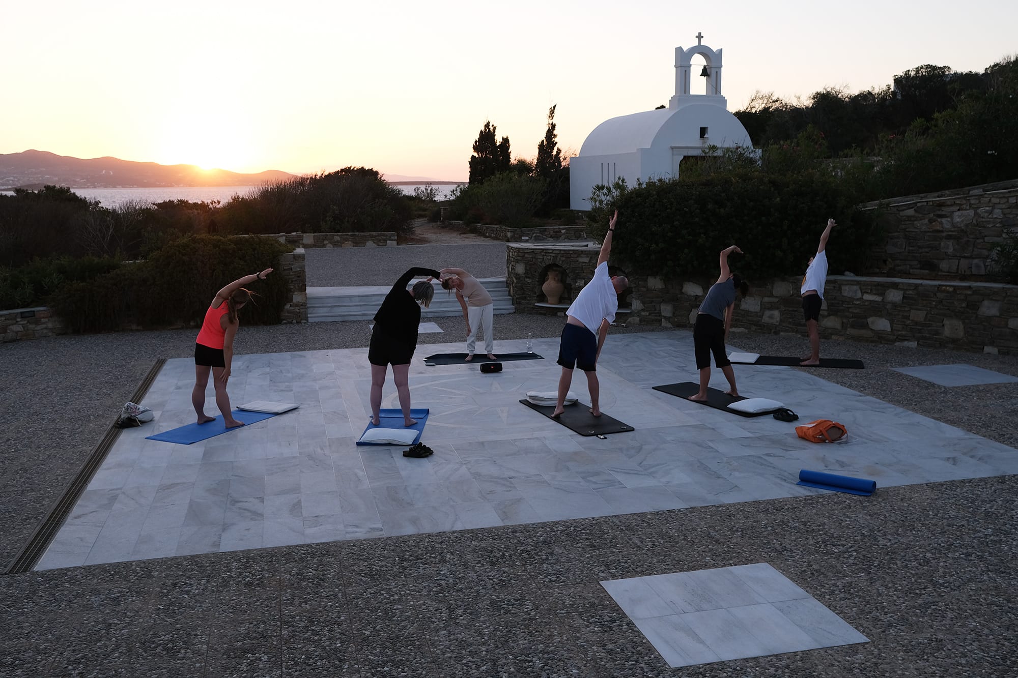 Fotografi seks Fiken-ansatte som gjør yoga utendørs.