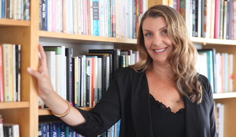 Claire Bidwell Smith in front of book shelves.