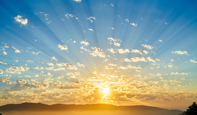 A bright sunrise over a mountain range.