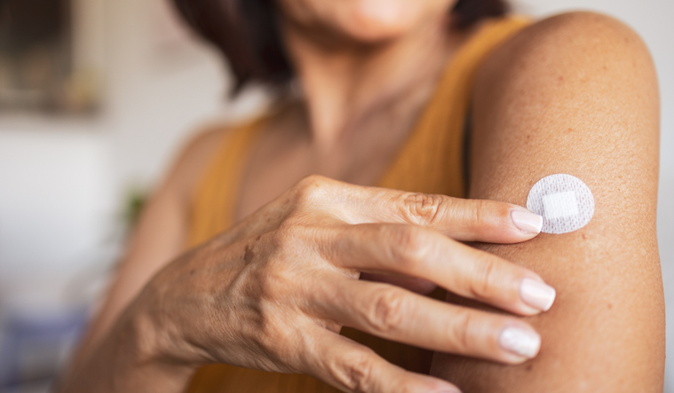 Woman applying a hormone patch
