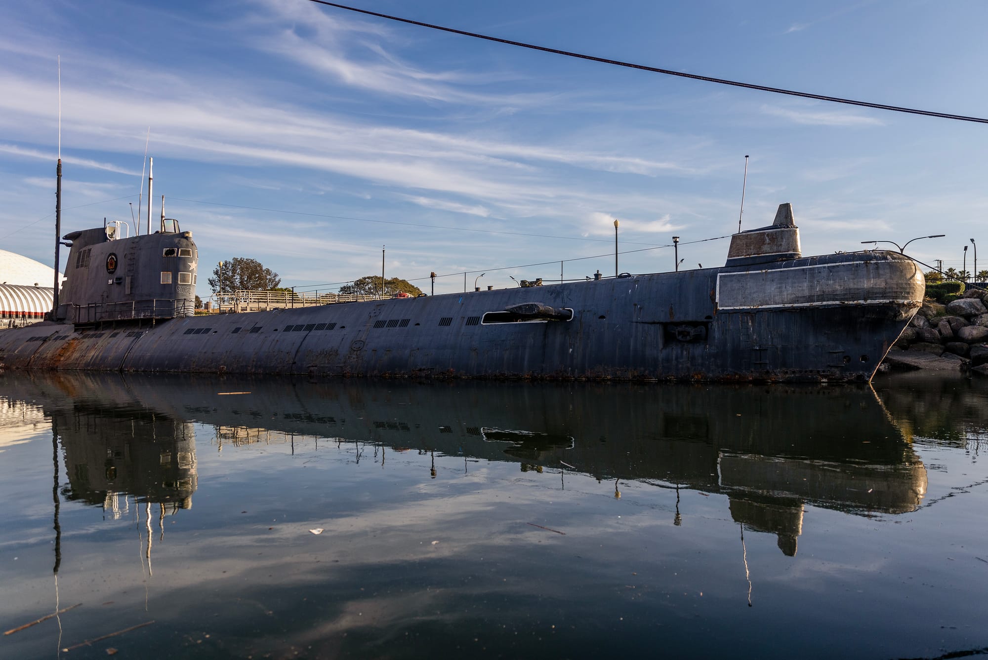 An old submarine sits in water.