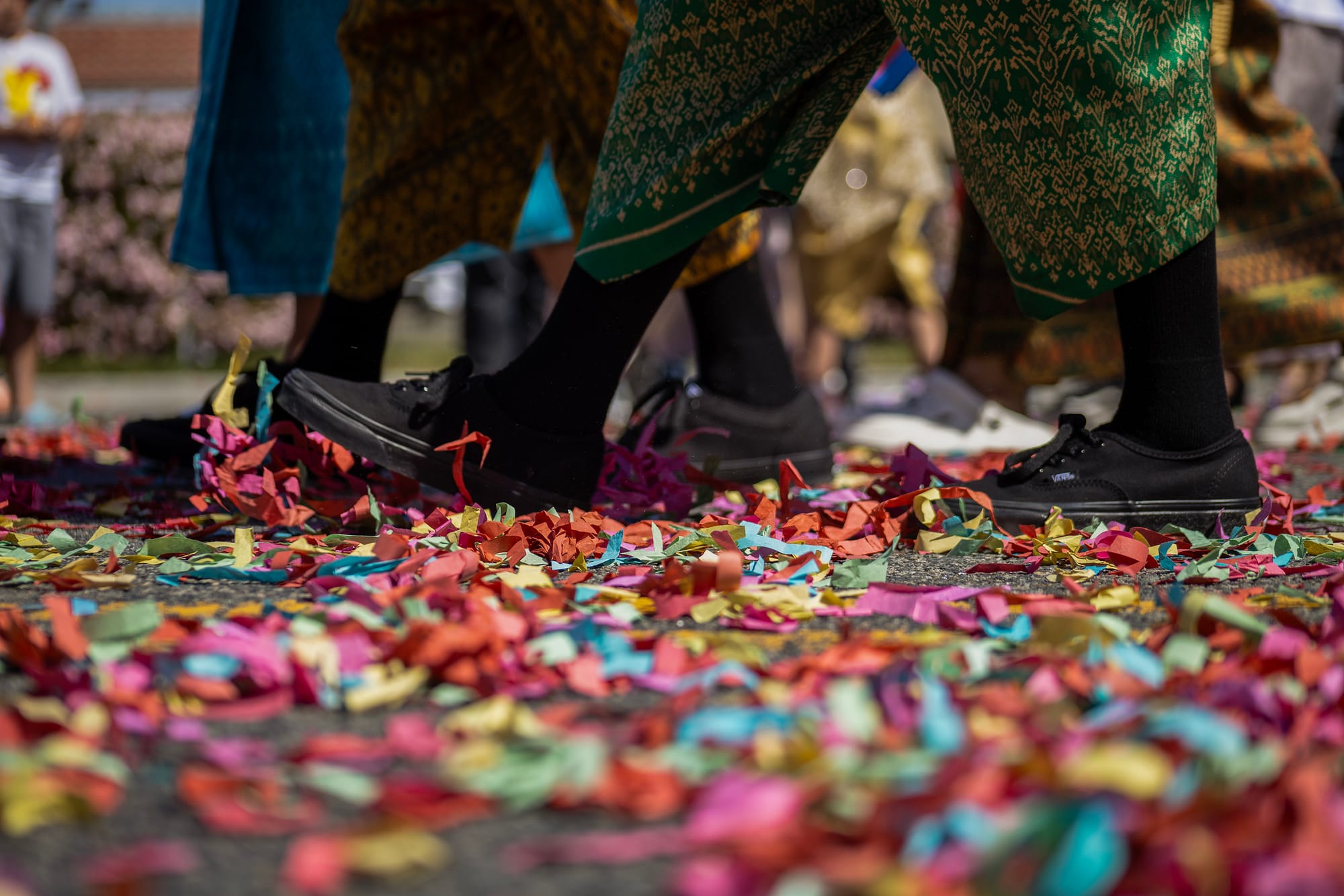 Close up shot of people's shoes as they walk over confetti.