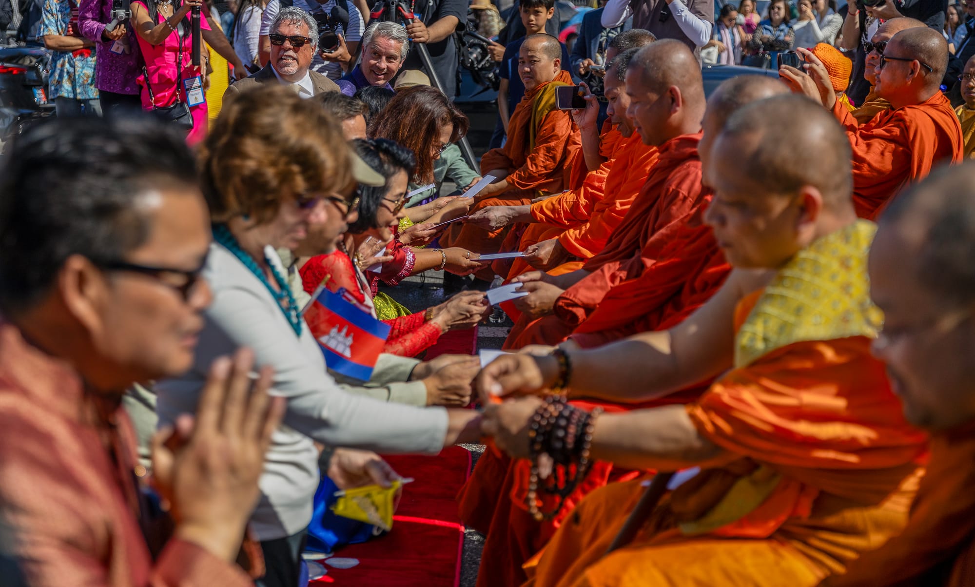 A group of people, some wearing bright orange robes.