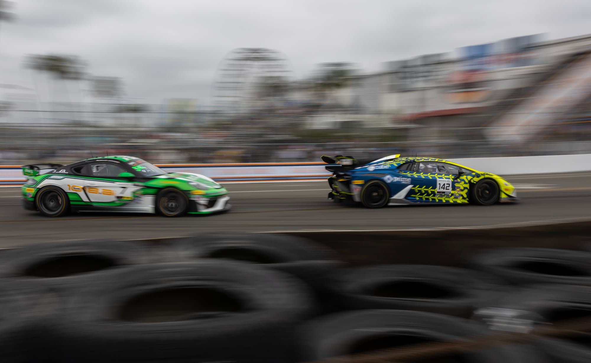 Slightly blurry photo of a white and green car chasing a blue and yellow car.