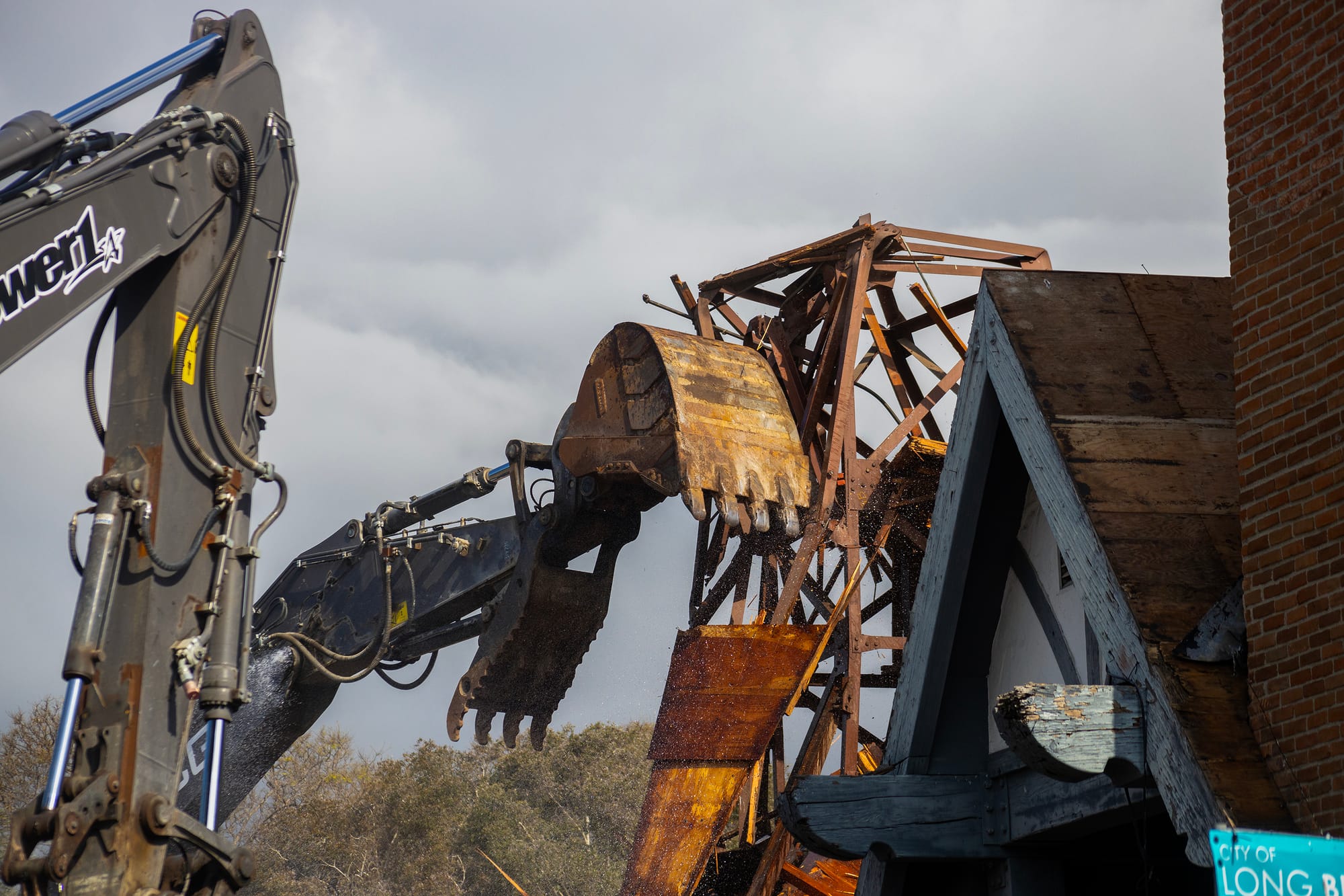 Construction equipment rips apart a building.