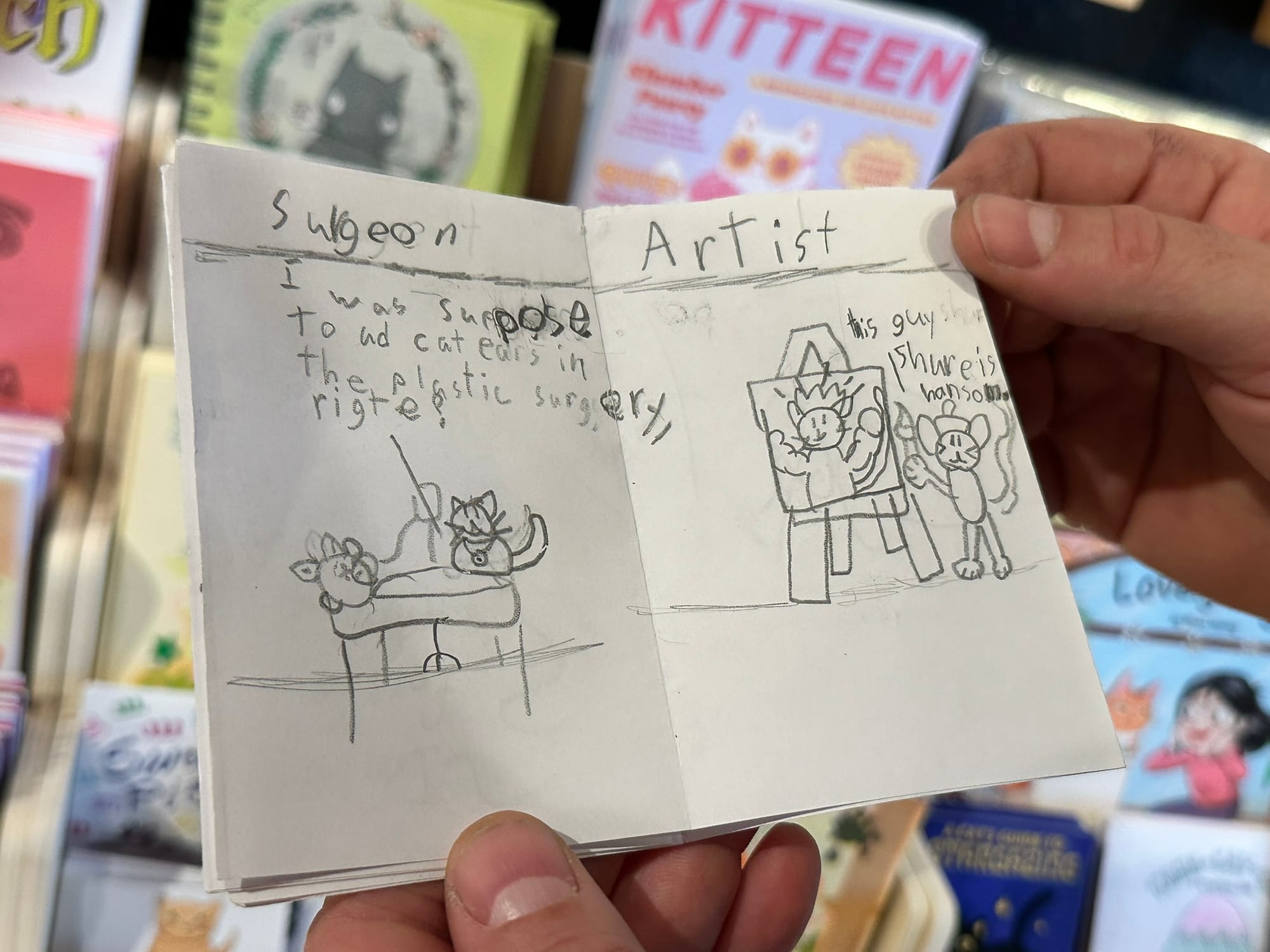 Two hands holding open a small zine.