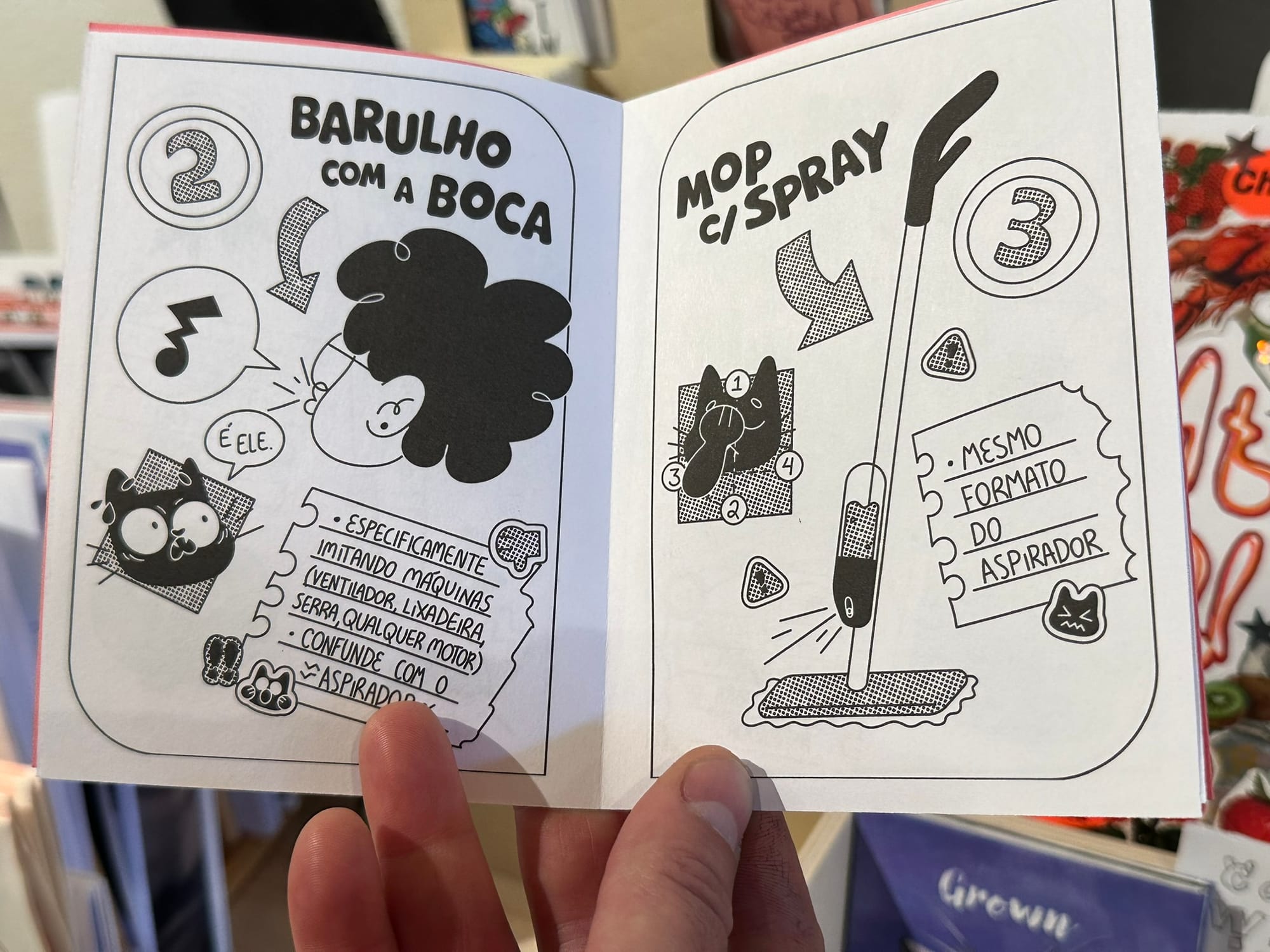 A hand holding open a small zine.