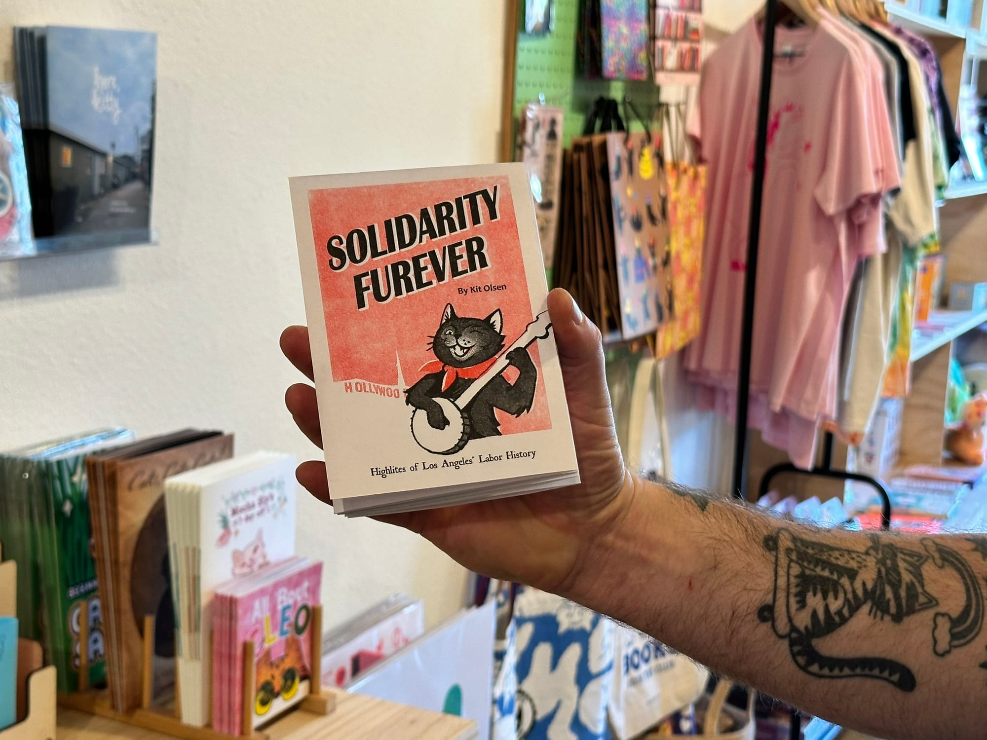 A hand holding a zine titled "Solidarity Furever."