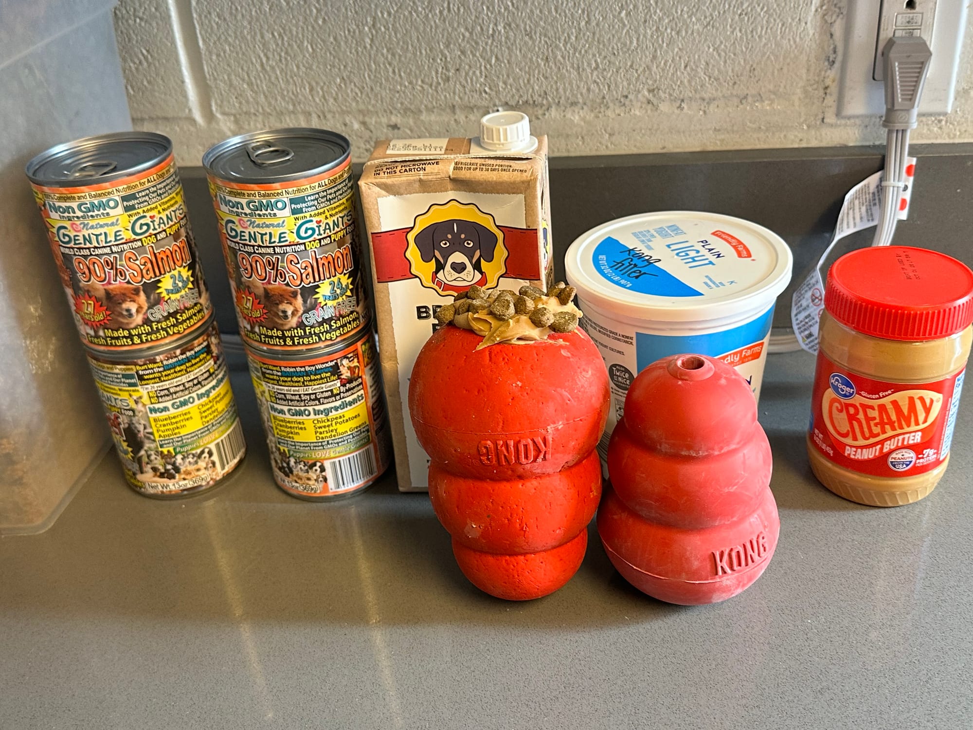 Assorted canned foods and red dog toys.