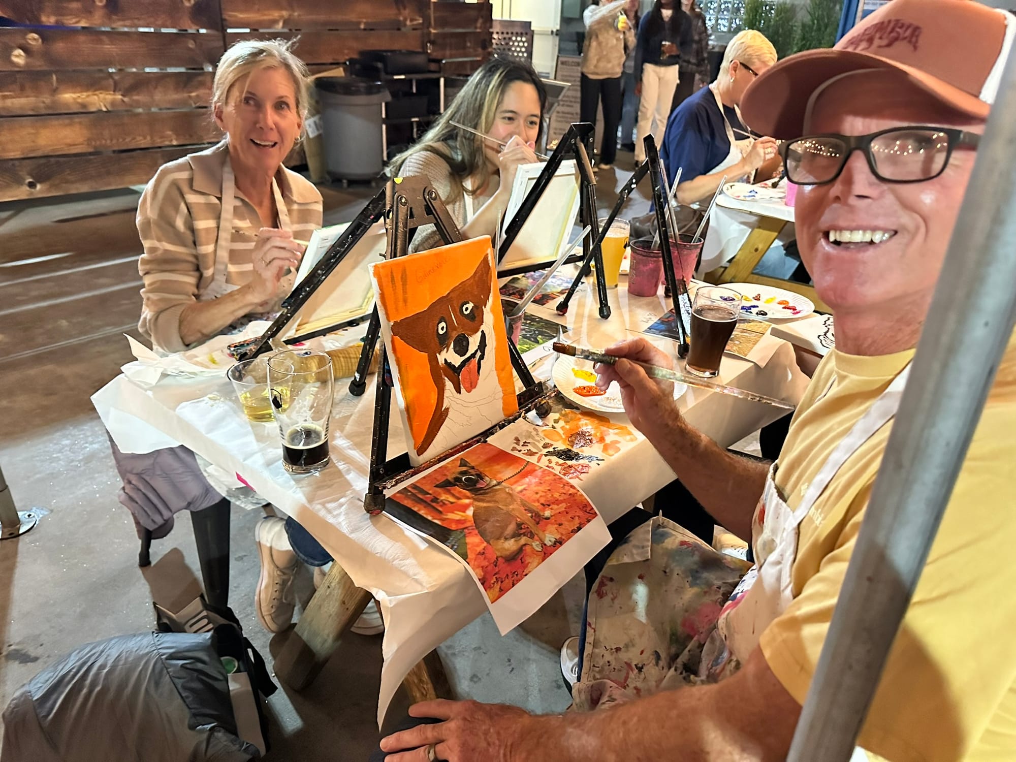 People sit at a table painting. 