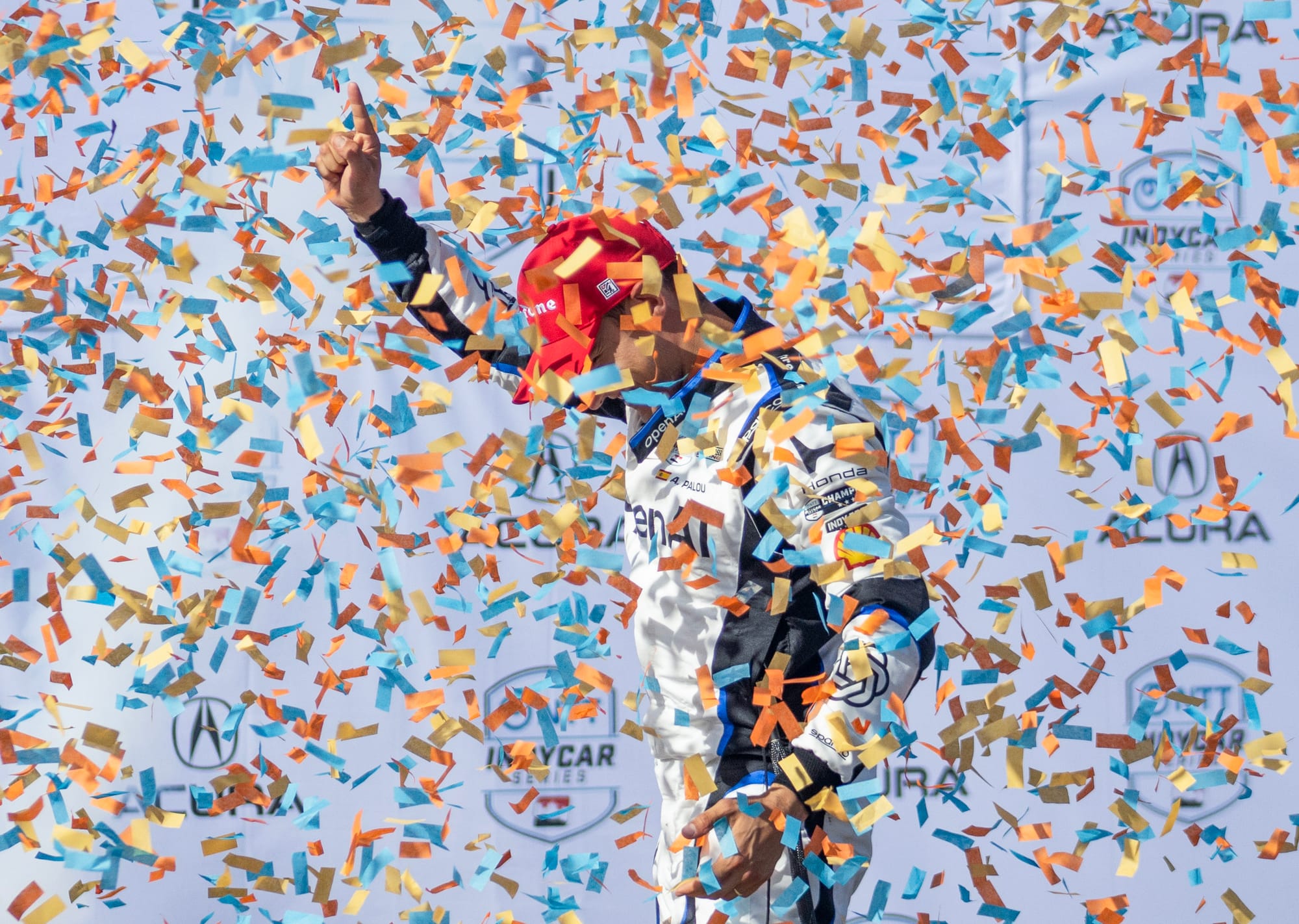 A man holds up a finger as he is showered in colorful confetti.