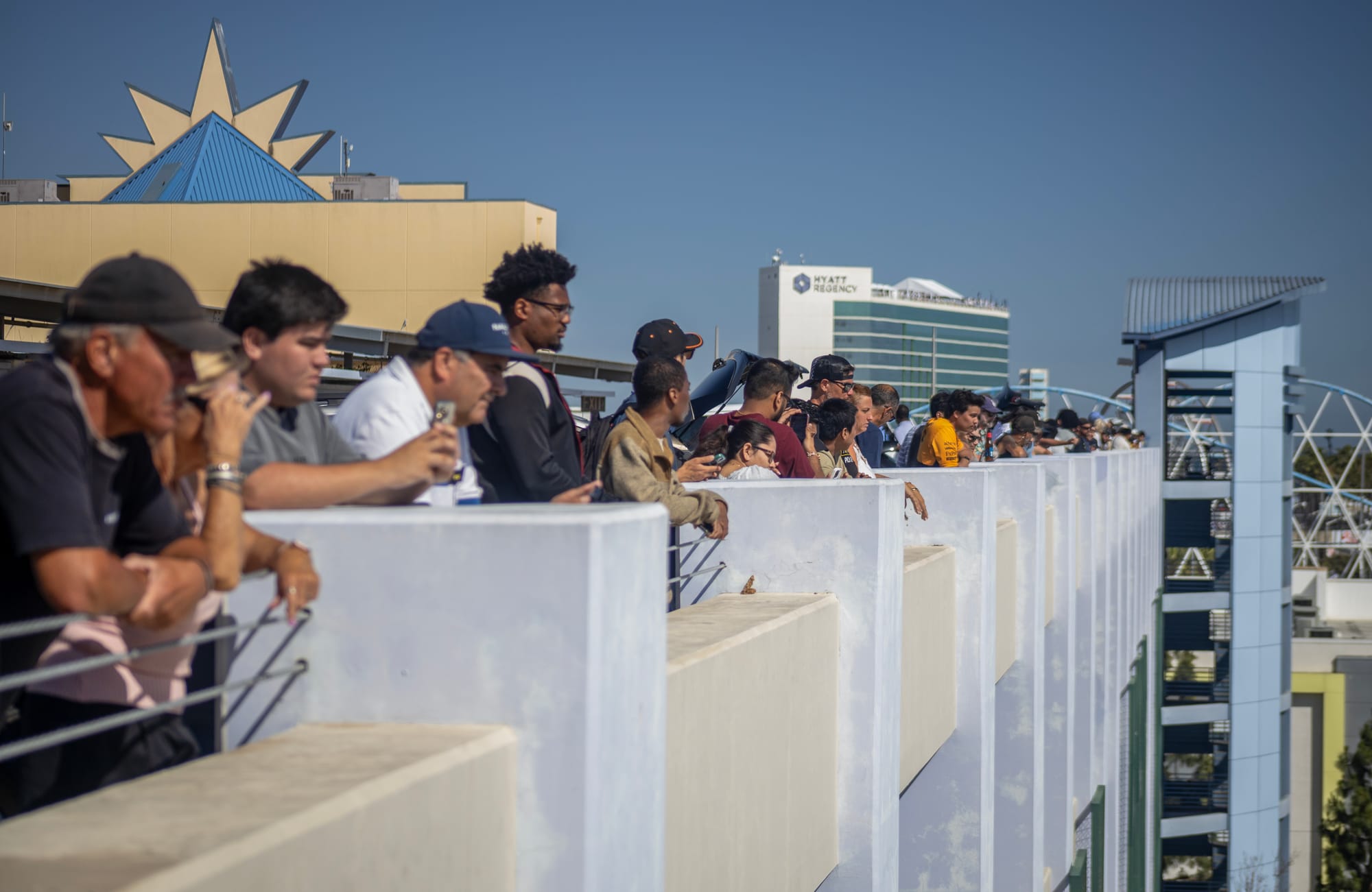 People stand along the top of a building.