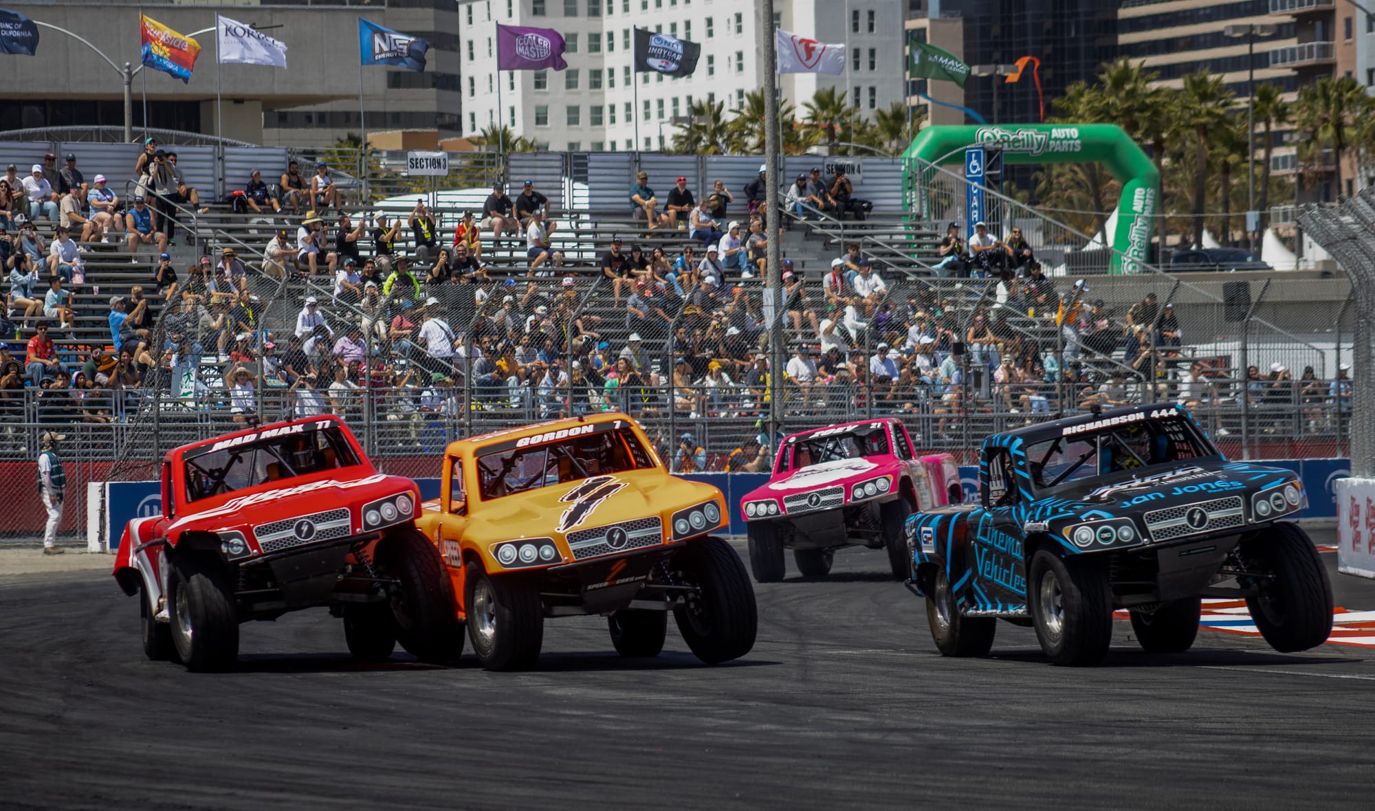 Colorful trucks race along a race track.