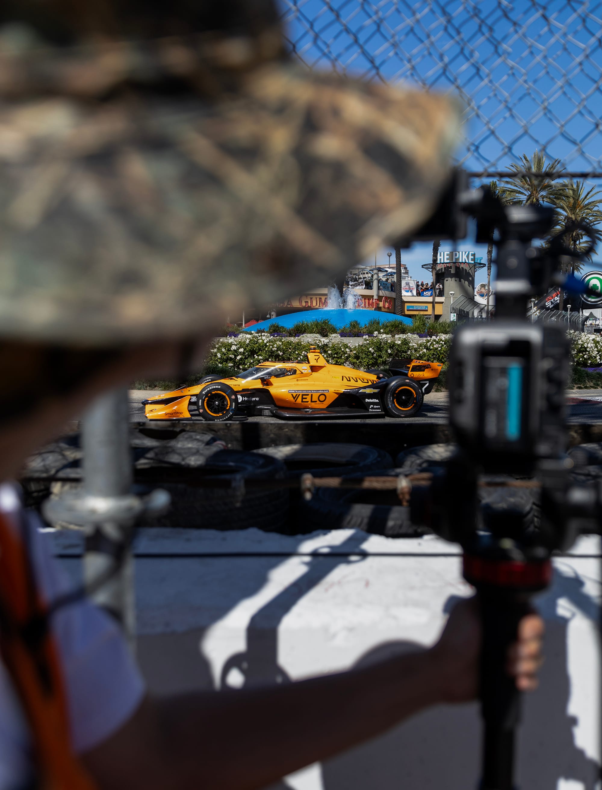 A blurry person takes a photo of a yellow race car.
