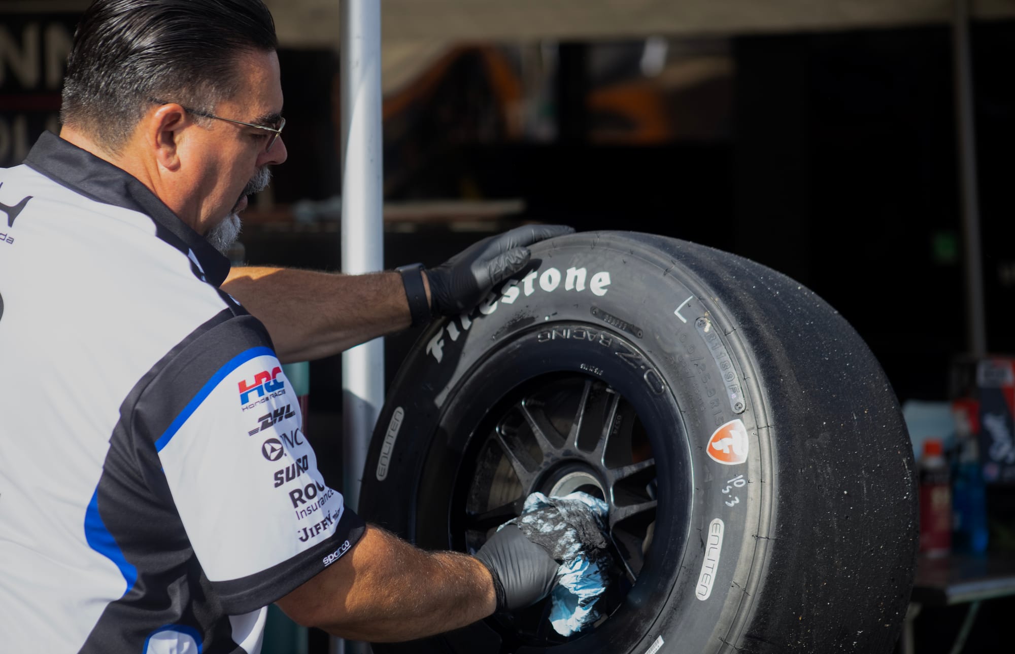 A man works on a race car wheel.