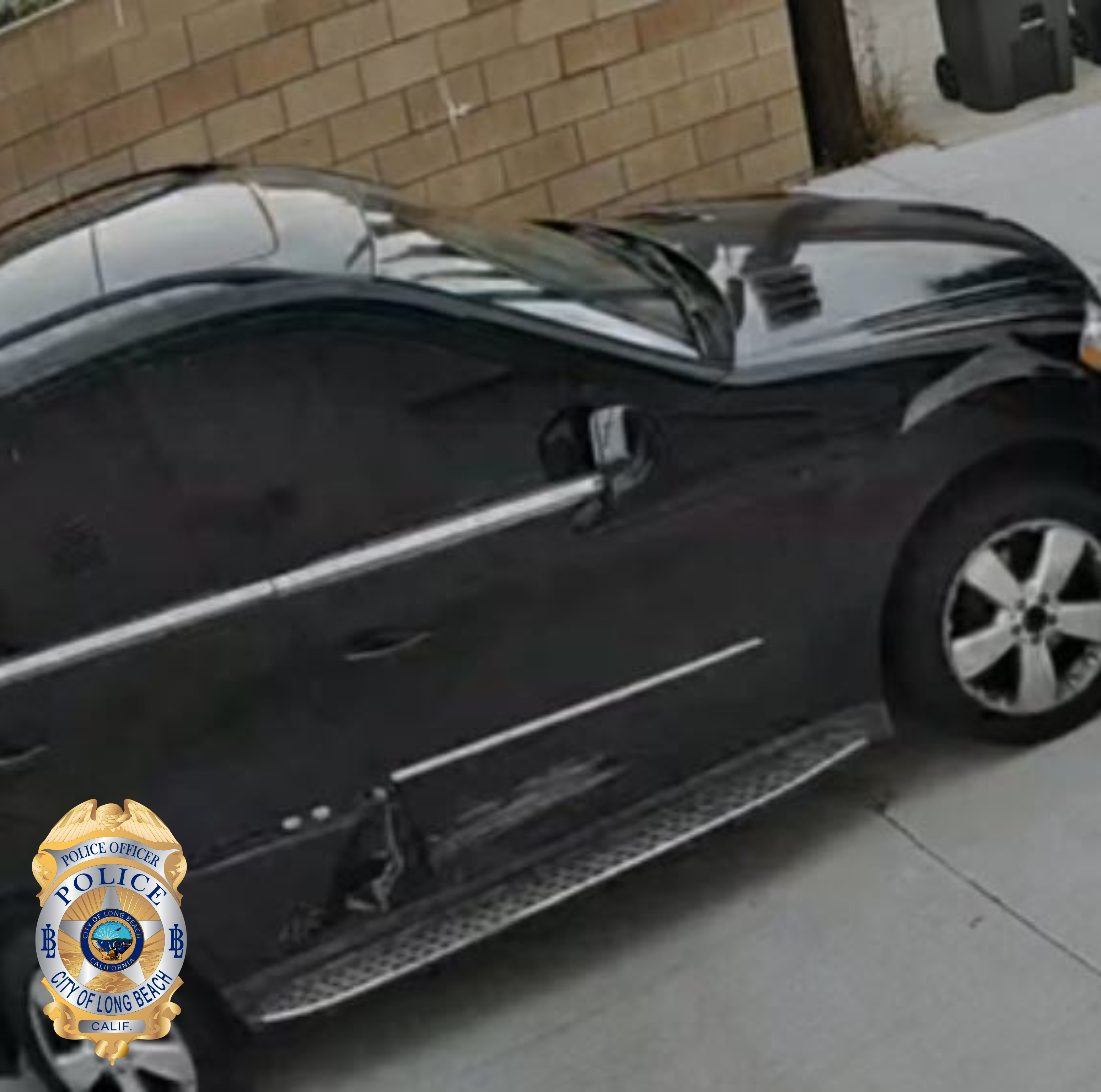 Surveillance camera photo of a black car with tinted windows and damage on the right passenger doors.