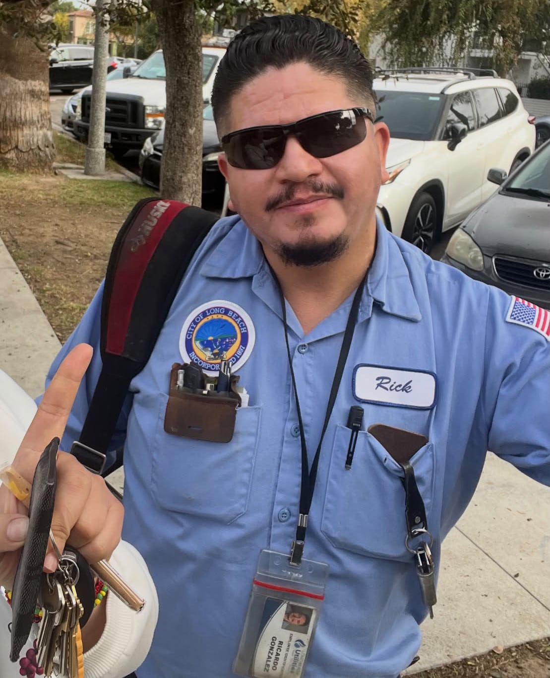 A man in a light blue City of Long Beach uniform with the name tag "Rick."